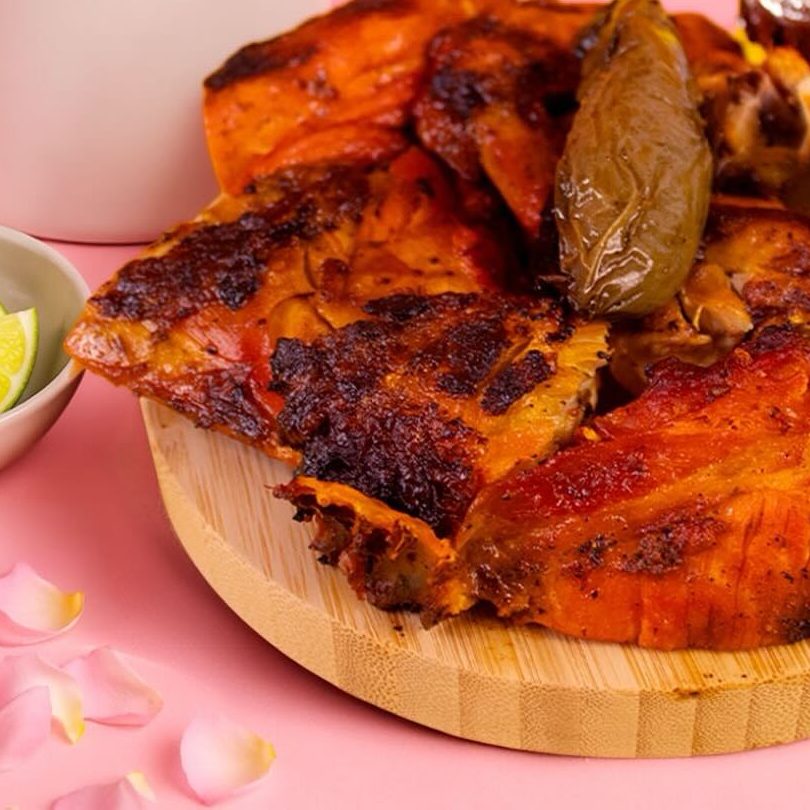 Pollo asado con chile toreado sobre una tabla de madera